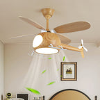 Close view of the helicopter fan from Clérachic with its light on, with leaves drifting in the airflow above a framed picture and a bedhead.