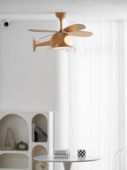 Side view of the helicopter fan from Clérachic against sheer white curtains, with an arched white shelf and a small round table below.