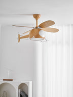 Closer view of the wood-grain helicopter ceiling fan from Clérachic, with its tail propeller, against sheer white curtains.