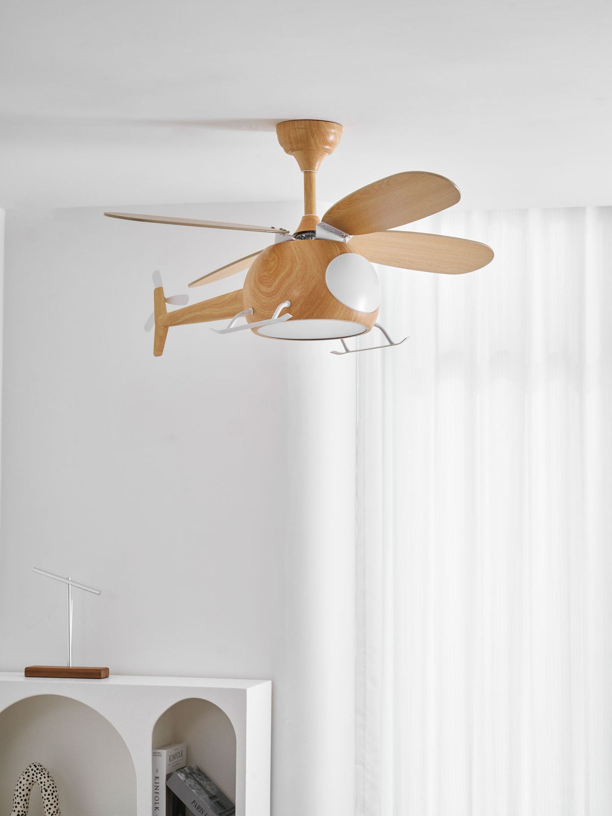 Closer view of the wood-grain helicopter ceiling fan from Clérachic, with its tail propeller, against sheer white curtains.