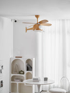 A helicopter-shaped Clérachic ceiling fan seen at a distance, with sheer curtains behind and an arched shelf and a white table below.