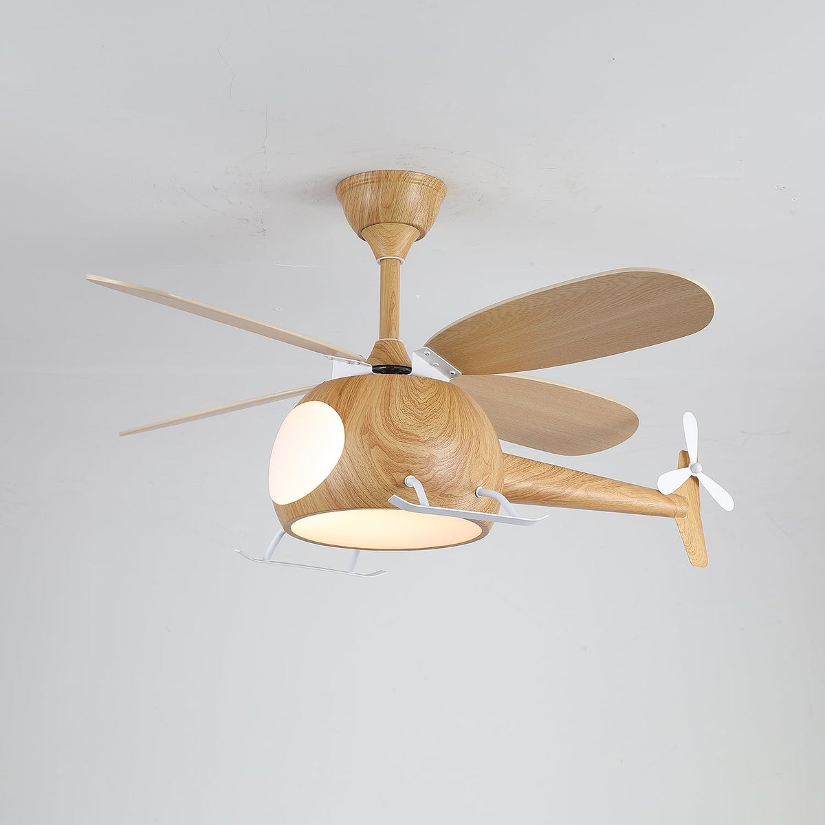 A warm light glows under the cabin of this wood-grain Clérachic helicopter fan on a pale grey ceiling.