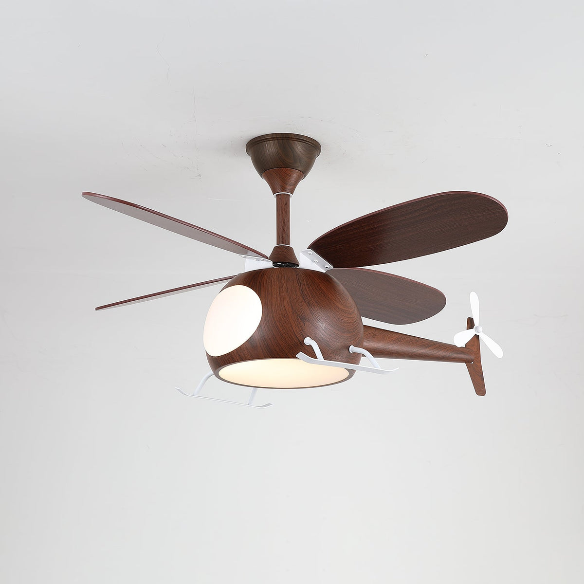 The walnut-toned Clérachic helicopter ceiling fan with a warm light glowing under the cabin, against a grey ceiling.