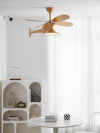 A Clérachic helicopter ceiling fan, high in a white room beside sheer curtains, with an arched shelf unit and table below.