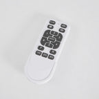 Remote control for this Clérachic ceiling fan, with number keys, fan and light buttons and timer keys, on a pale grey surface.