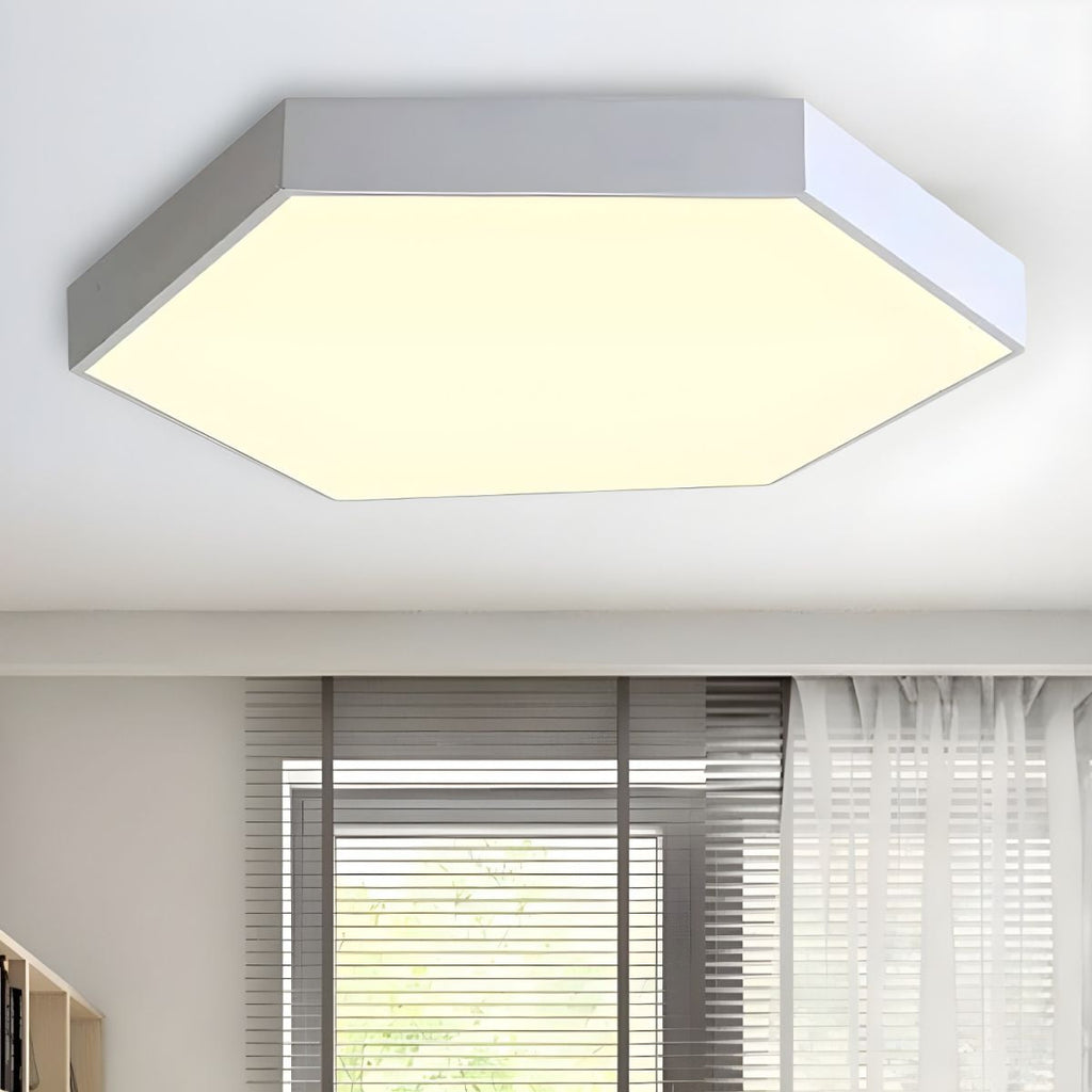 Silver-toned Clérachic hexagon flush mount ceiling light casting warm light beside a curtained window.
