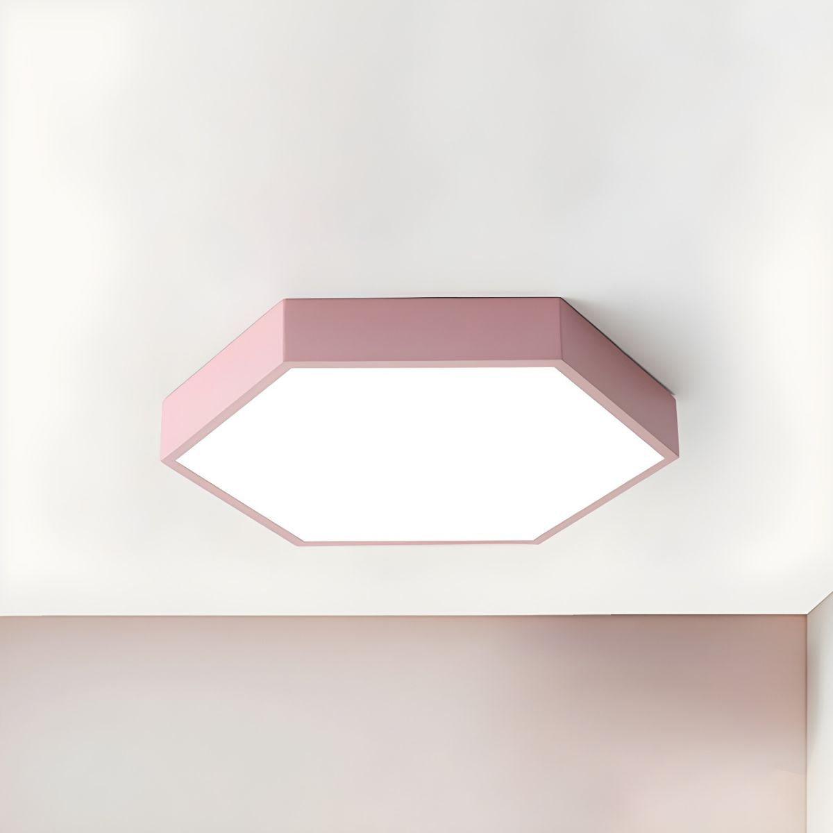 Dusty pink Clérachic hexagon flush mount glowing softly on a plain white ceiling.