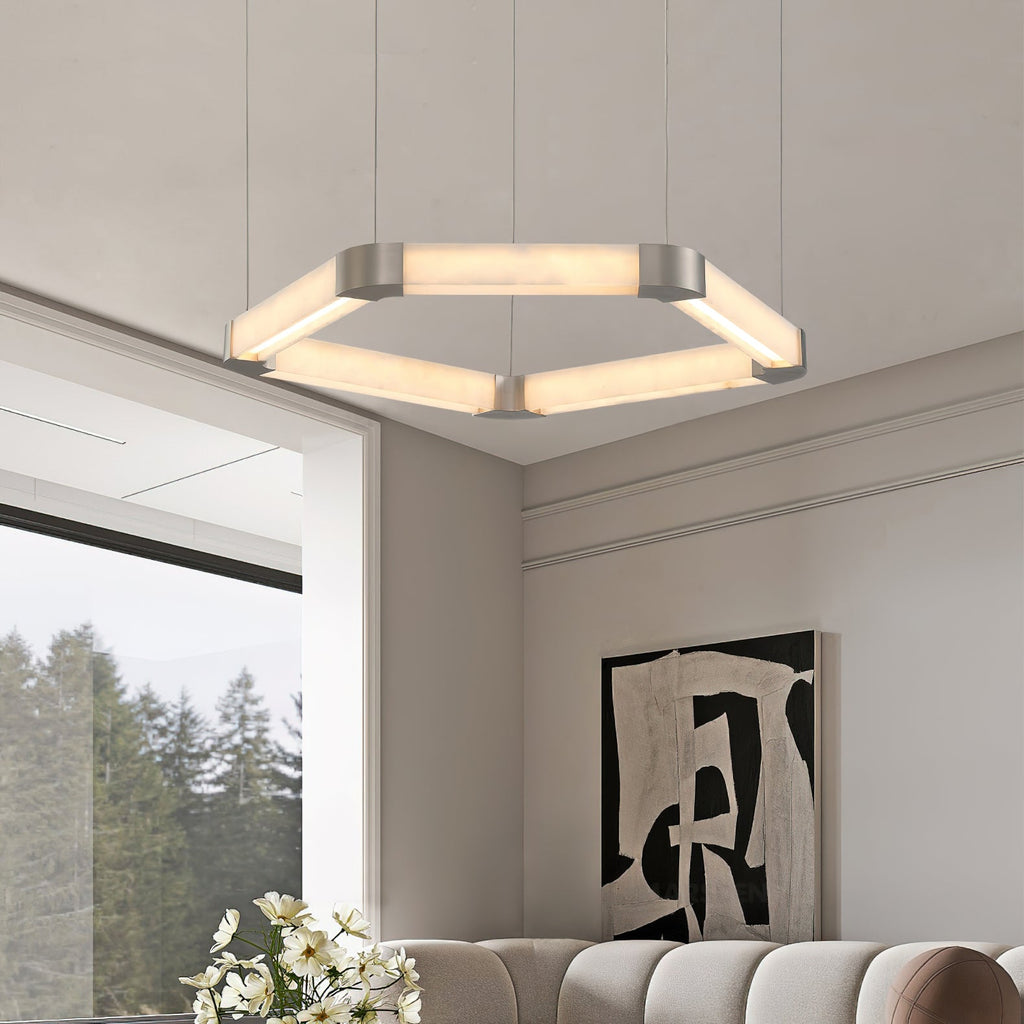 Clérachic Hexagonal Alabaster Chandelier glowing warm above a living room with a curved sofa and a wide forest window.