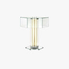 Hexagonal clear-glass table lamp with a lit column of light tubes and a flat glass base, from Clérachic, on a plain white backdrop.