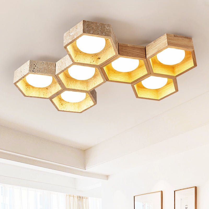 Seven lit hexagonal cells of this Clérachic ceiling light seen from below in a bright cream room with framed art on the wall.