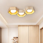 Three-cell version of this Clérachic travertine ceiling light over a wardrobe wall in pale wood, glowing warm gold.