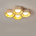 Five-cell layout of this Clérachic ceiling light, mixing wood and travertine hexagons with warm light inside each cell.