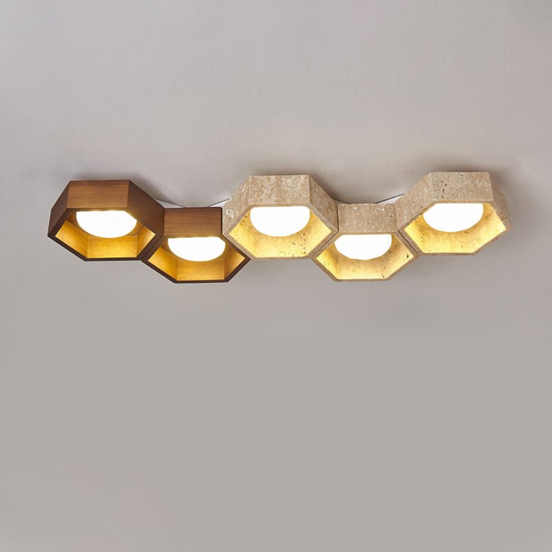 Five hexagons in a long low row, the first two in walnut tone and the rest travertine, on this Clérachic ceiling light.