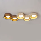 Five hexagons in a long low row, the first two in walnut tone and the rest travertine, on this Clérachic ceiling light.