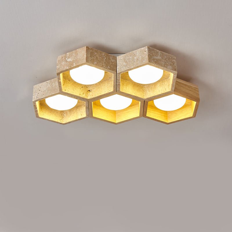 Five travertine and light-wood hexagons of this Clérachic ceiling light in two staggered rows, glowing on a grey backdrop.