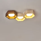 Three hexagons side by side, a dark walnut cell at the left and two travertine ones, on this Clérachic ceiling light.