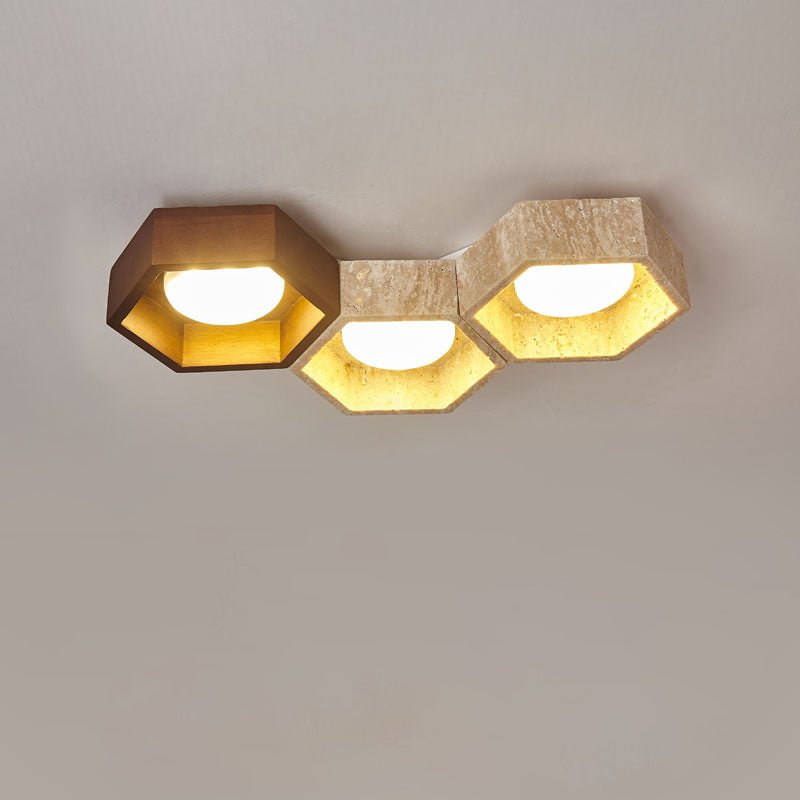 Three hexagons side by side, a dark walnut cell at the left and two travertine ones, on this Clérachic ceiling light.