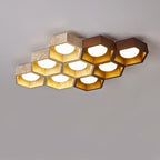 Large honeycomb of this Clérachic ceiling light, travertine cells with three dark walnut ones at the upper right, lit.
