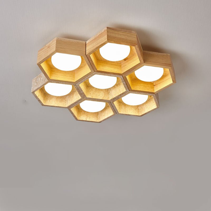 Seven light-wood hexagons of this Clérachic ceiling light in a tight honeycomb, glowing warm gold on a grey backdrop.