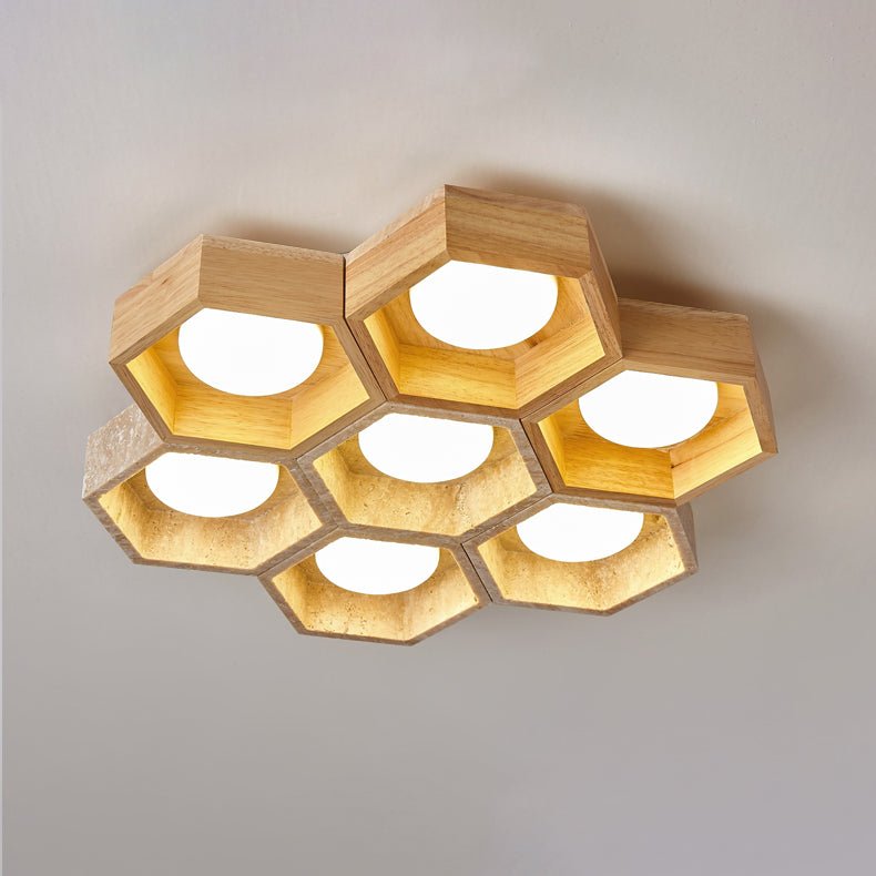 Seven wood-framed and travertine hexagons of this Clérachic ceiling light seen from below, each with a lit white disc.