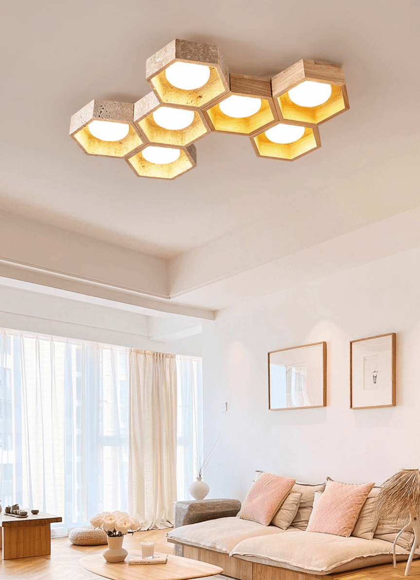 Seven-cell Clérachic ceiling light in a living room with a pink sofa, sheer curtains and two framed prints on the wall.