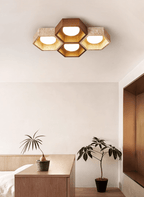 Four-cell Clérachic ceiling light with a walnut centre over a bedroom corner with a wooden console and a leafy plant.