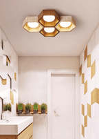 Four-cell Clérachic ceiling light in a small washroom with a white basin, herb planters and gold-and-white wall tiles.