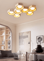 Seven-cell Clérachic ceiling light in a living room with an arched shelving alcove, a grey sofa and a black teapot.