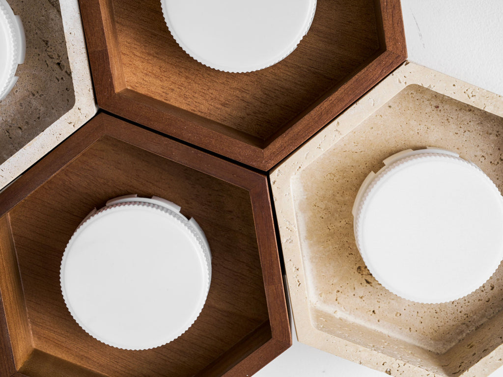 Close view of walnut and travertine hexagon cells on this Clérachic ceiling light, with the white disc lamps visible inside.