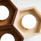 Close view of a travertine hexagon on this Clérachic ceiling light, with the stone's pitted surface and a glowing disc.