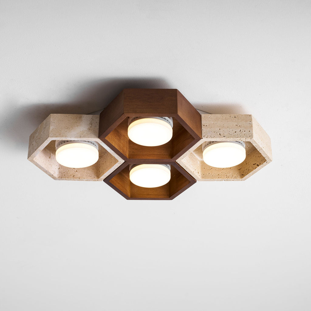 Side view of this Clérachic ceiling light with a walnut centre pair and travertine ends, the discs glowing softly.