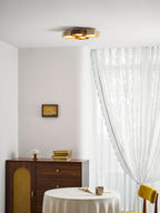Clérachic ceiling light glowing high on a white ceiling over a walnut sideboard, a lace-clothed table and a yellow chair.