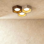 Clérachic ceiling light of three hexagonal walnut and travertine frames, each with a gold-leaf interior and a lit opal glass globe.