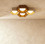 Clérachic four-head honeycomb ceiling light of walnut and travertine hexagons with gold-leaf interiors and glowing opal globes.