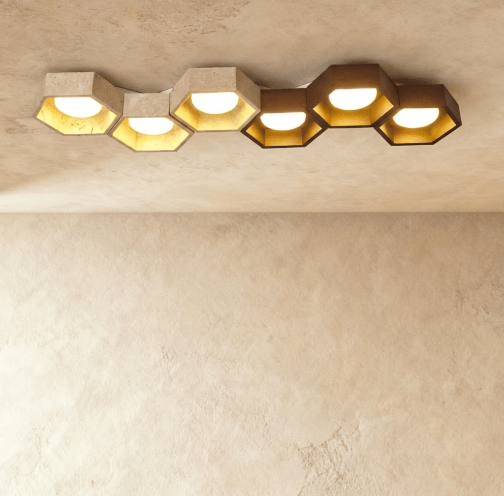 Clérachic six-head ceiling light, a long honeycomb of travertine and walnut hexagons with gold-leaf interiors and glowing globes.