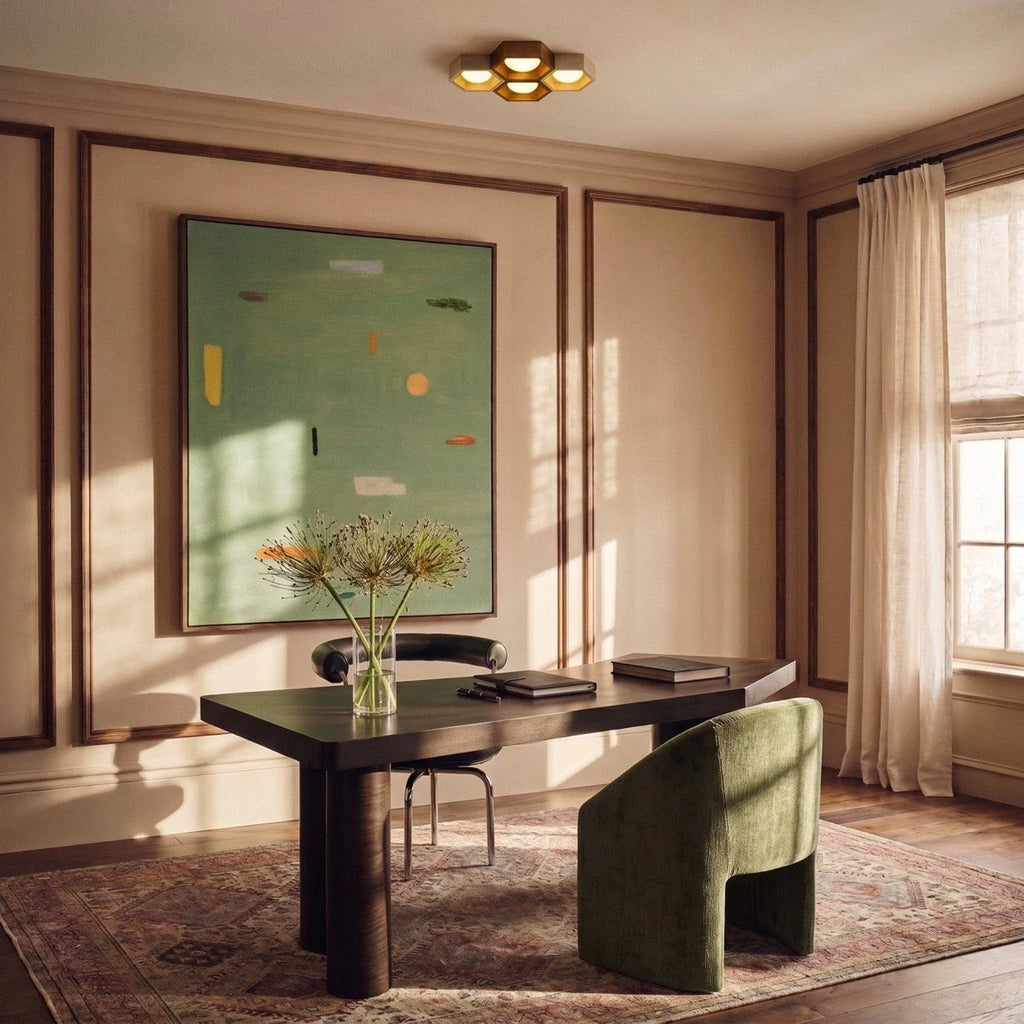 Clérachic four-head hexagonal ceiling light above a dark wood desk and green armchair in a panelled room with a large painting.