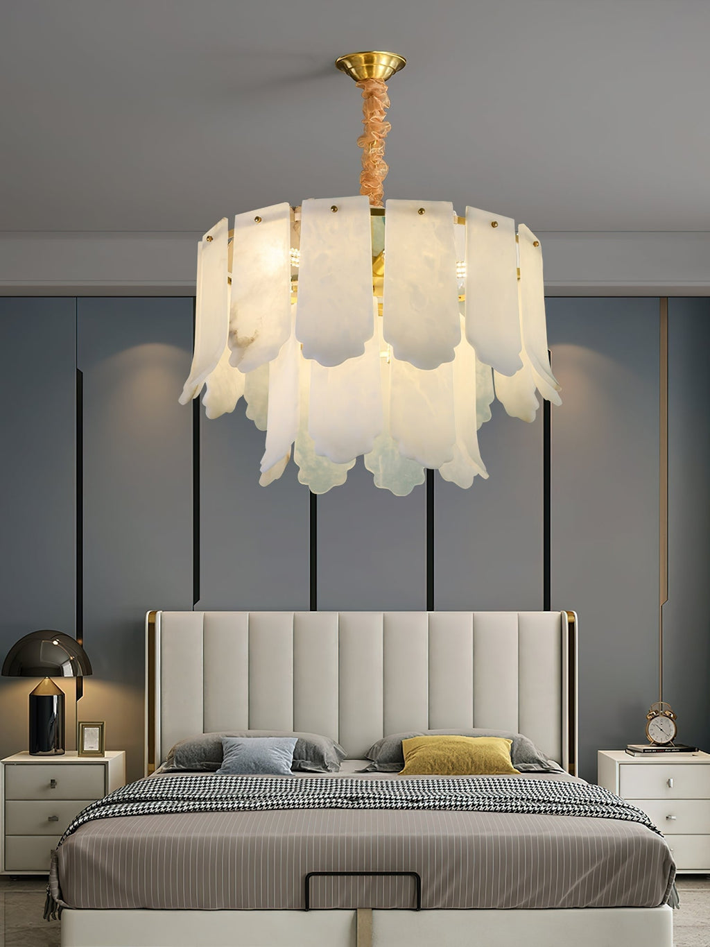The Clérachic Hue Alabaster Chandelier centred over an upholstered bed, its domed brass canopy fixed to a blue-grey bedroom ceiling.