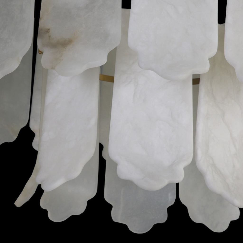Detail of the scalloped hems on the Clérachic Hue Alabaster Chandelier, one plate carrying a warm amber seam through white stone.