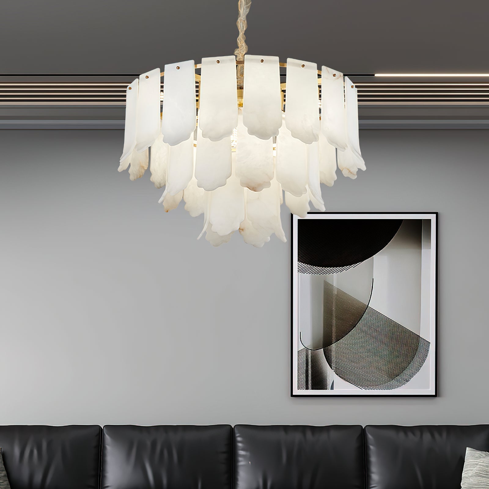 The Clérachic Hue Alabaster Chandelier lit above a black leather sofa and a framed abstract print in a grey-walled lounge.