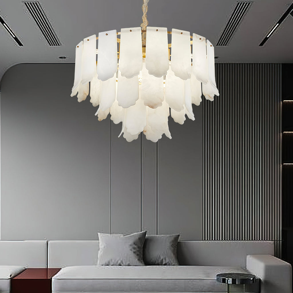 The Clérachic Hue Alabaster Chandelier lit in a contemporary lounge, framed by a ribbed feature wall and a low grey sofa.
