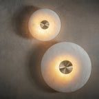 The Clérachic pair switched on, honeyed light glowing through the alabaster and pooling on the wall behind.