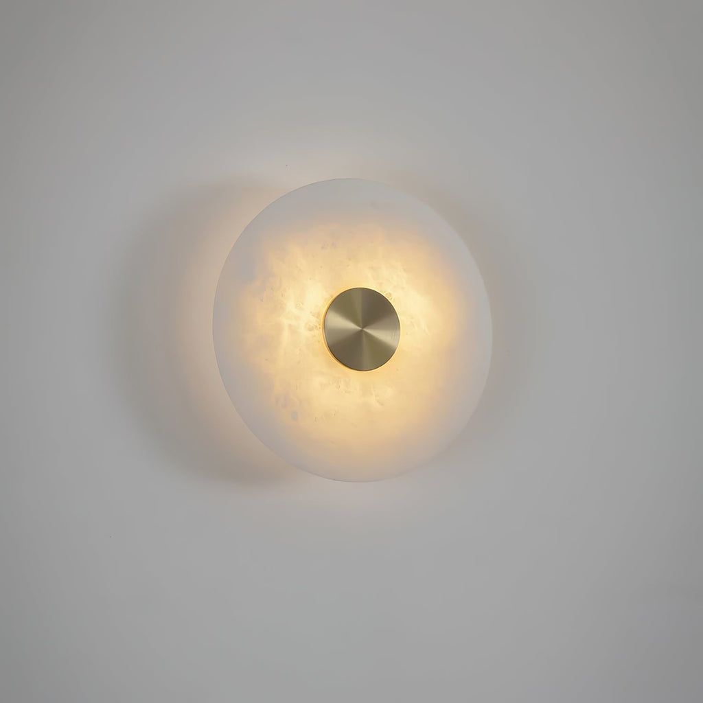 The Clérachic wall lights mounted so the two discs overlap, lit warm against a pale, softly shadowed wall.