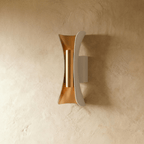 Clérachic white curved metal wall lamp with a gold-toned inner reflector and cylinder, switched off on a plaster wall.