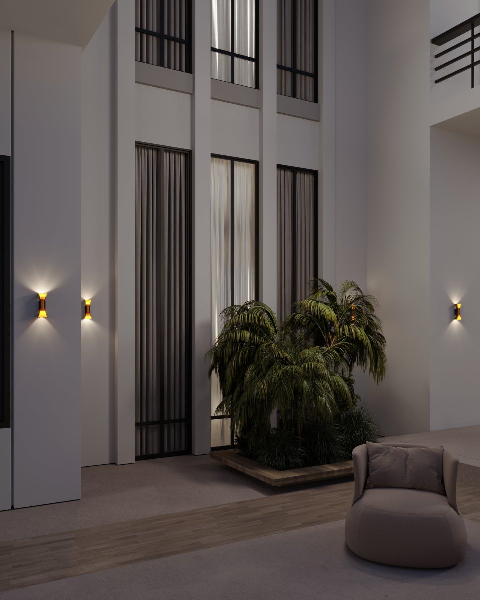 Several small Clérachic wall lamps with gold interiors glowing on pale walls in a tall hall with palms and a lounge chair.