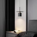 Clérachic black drum pendant with copper trim hanging as a bedside light over a grey nightstand.