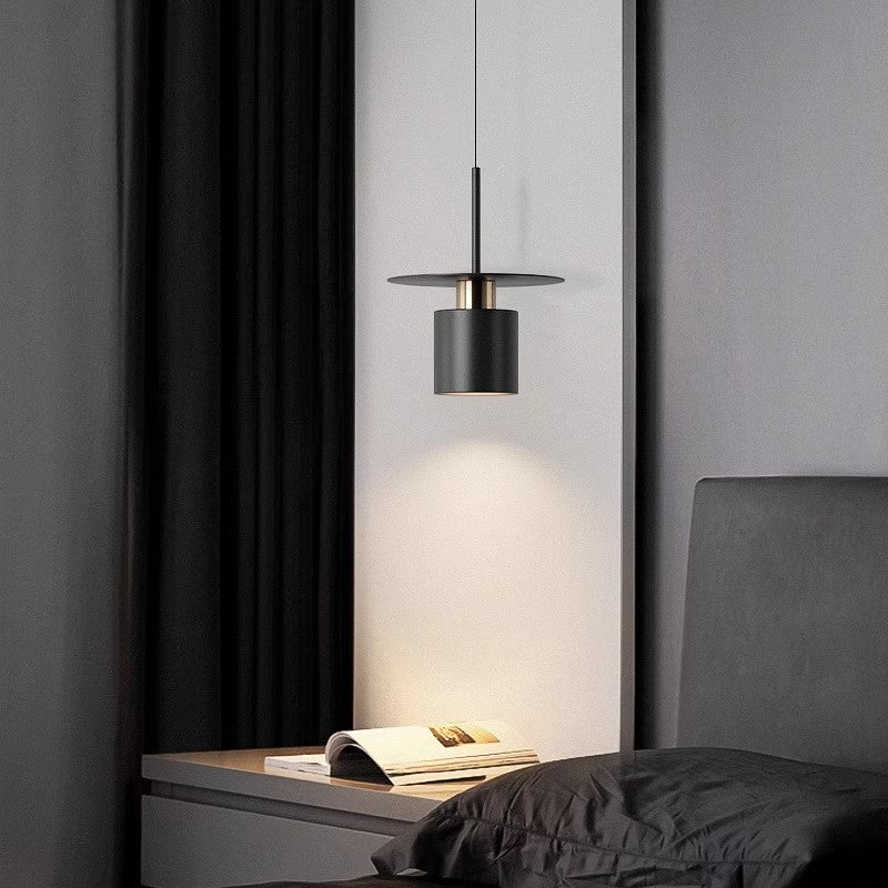 Clérachic black drum pendant with copper trim hanging as a bedside light over a grey nightstand.