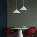 Two Clérachic white 1-light cone pendants hang at staggered heights over a round table and burgundy chairs.