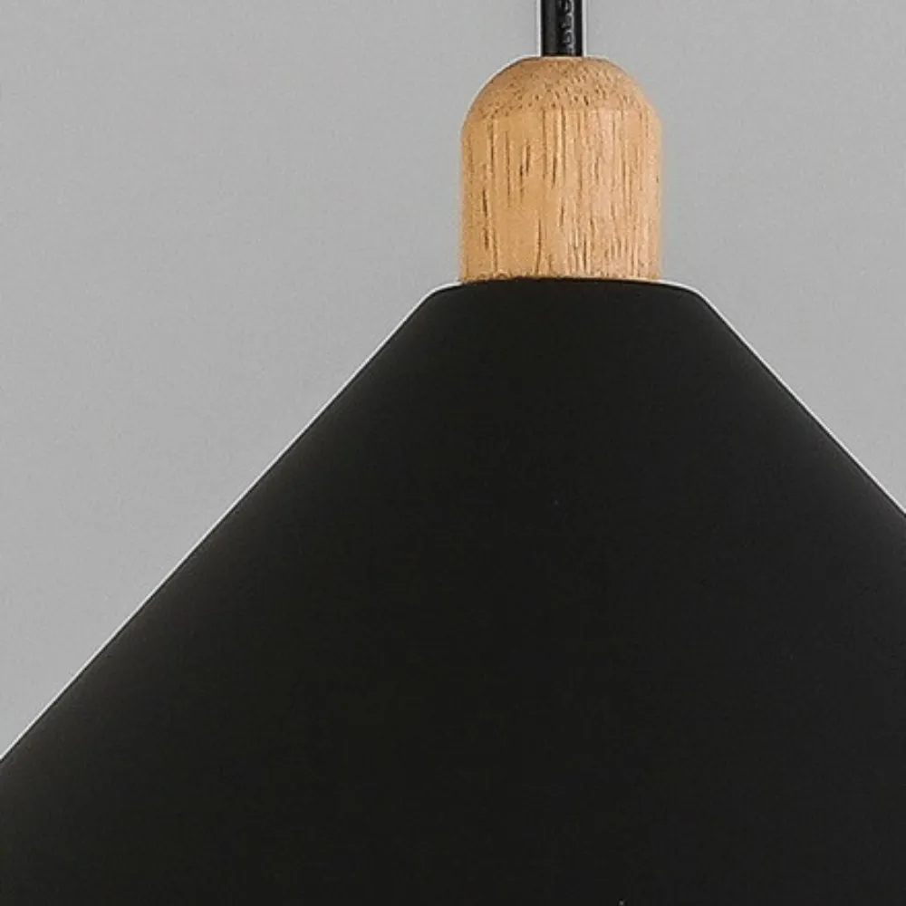 Close-up of the Clérachic black cone pendant, showing the light-wood cylinder where the black cord meets the shade.