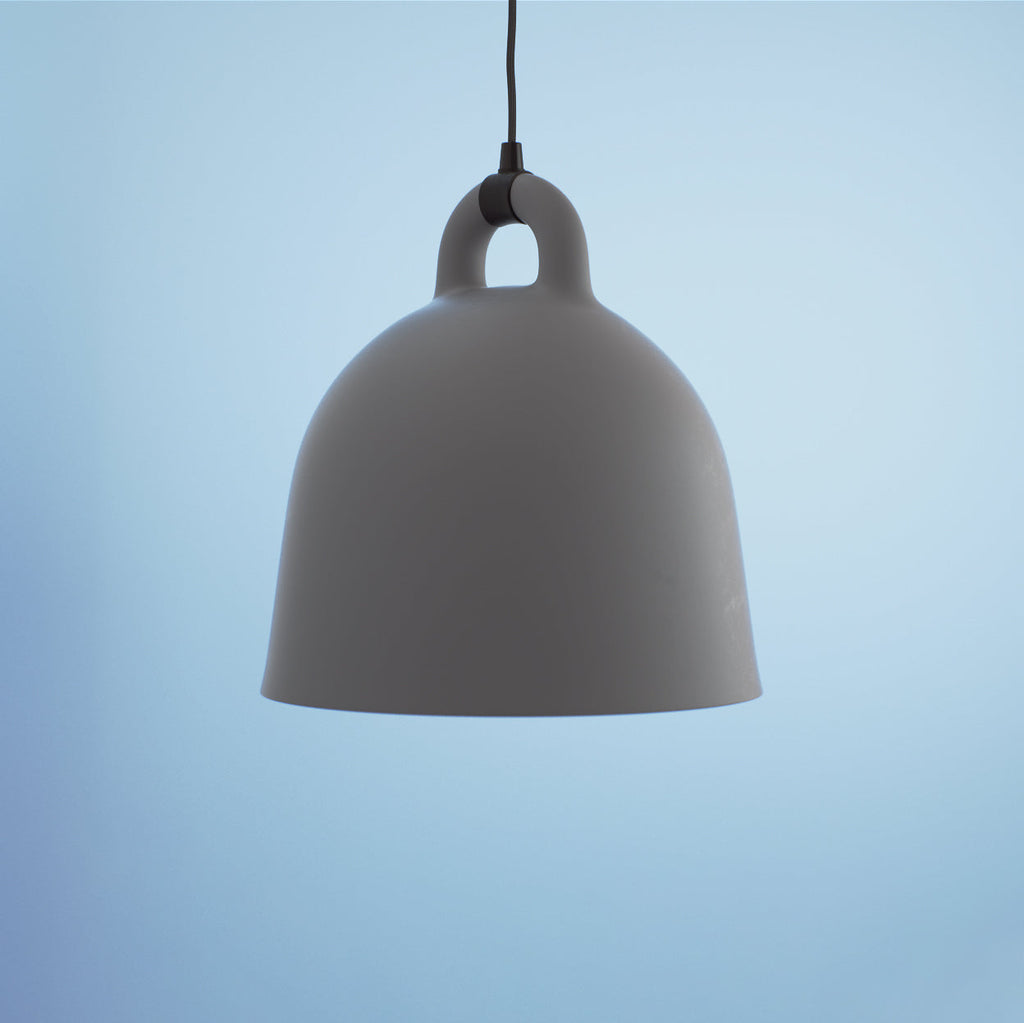 Close view of a large grey Clérachic bell pendant with matte finish, hanging against a pale blue backdrop.