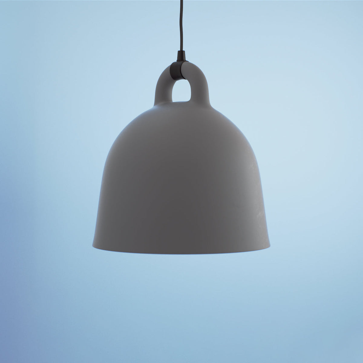 Close view of a large grey Clérachic bell pendant with matte finish, hanging against a pale blue backdrop.